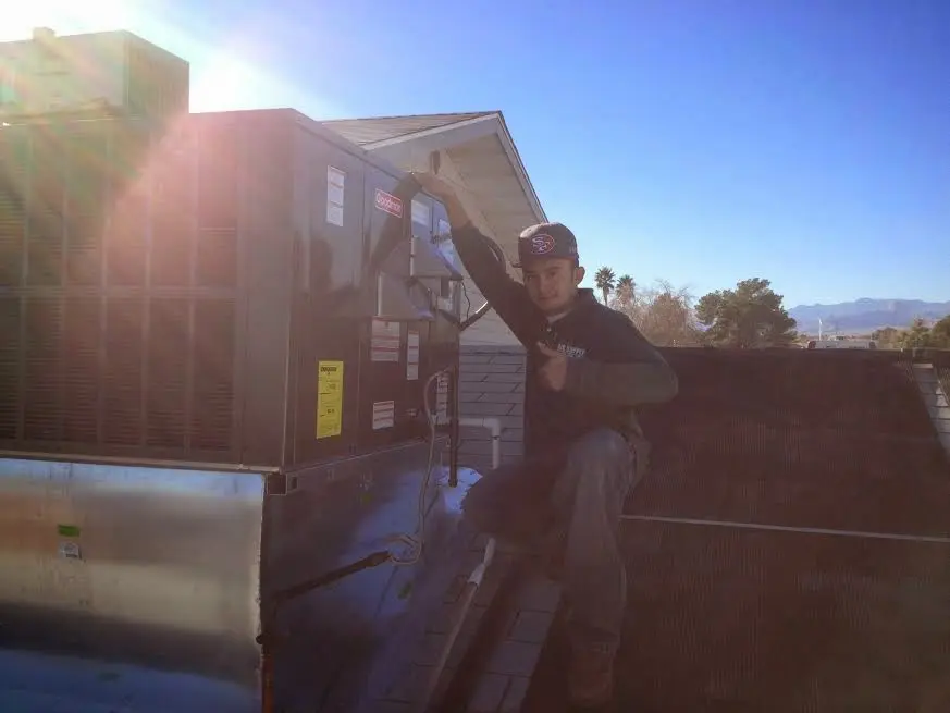 HVAC technician performing AC Tune-Up on a rooftop unit in Greenwood
